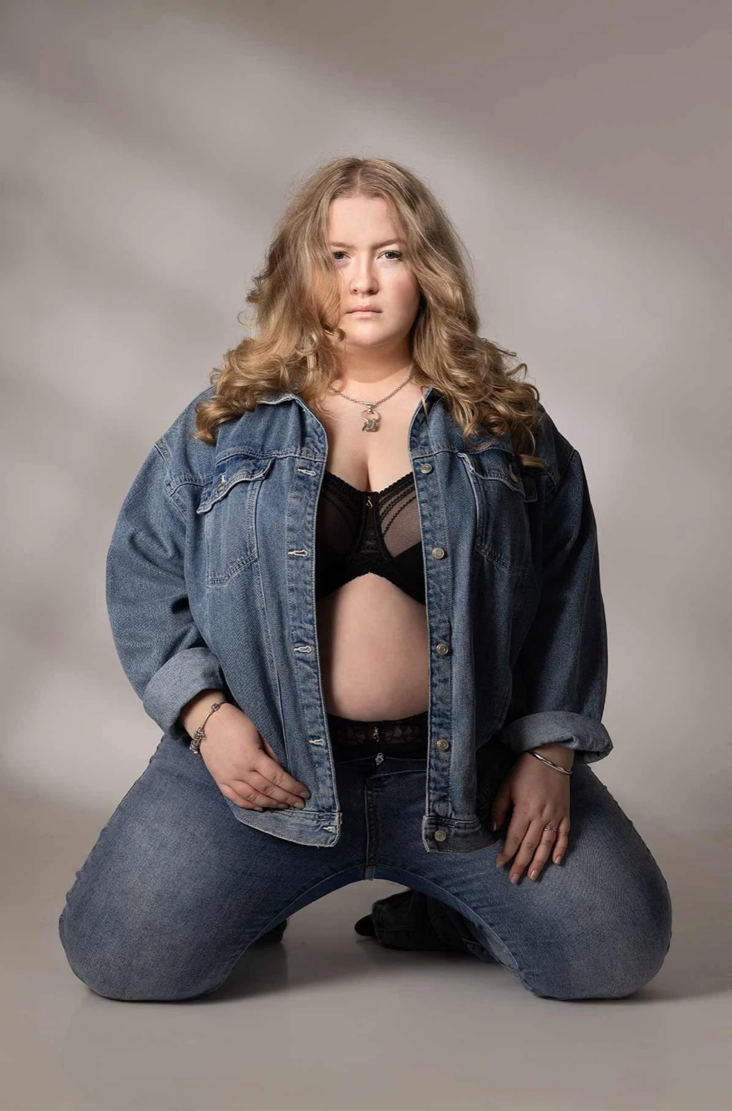 Confident boudoir portrait wearing a denim jacket