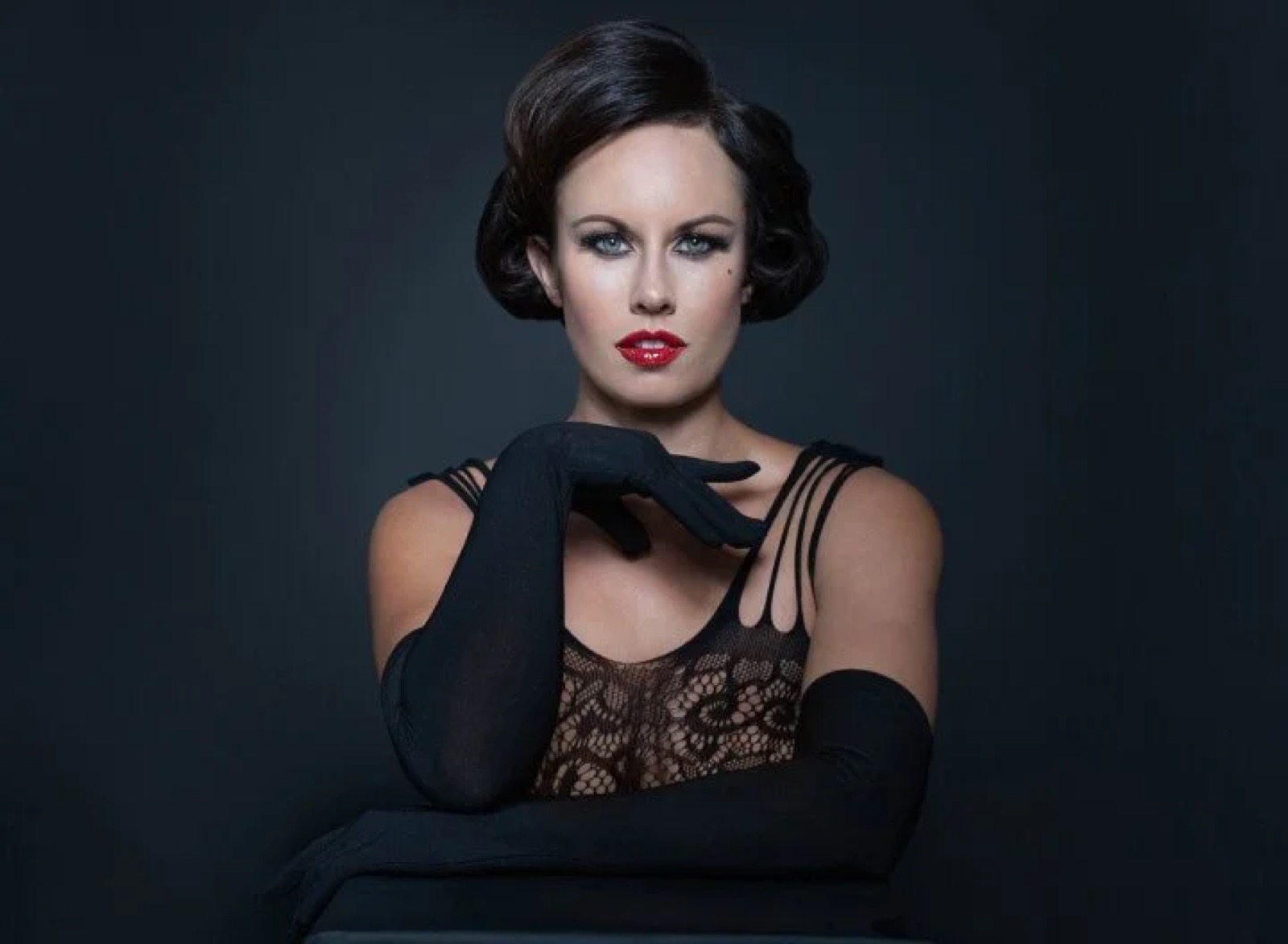 Boudoir photo of a woman looking at the camera wearing gloves